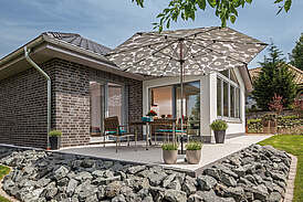 Haus Riedel Massivhaus Außenansicht Terasse mit Steinboden