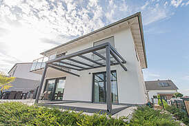 Haus Ullmer Massivhaus Außenansicht Terasse mit Überdachung aus Glas