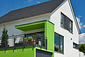 Haus Thiel Massivhaus Außenansicht mit grüner Garage mit begehbarem Dach